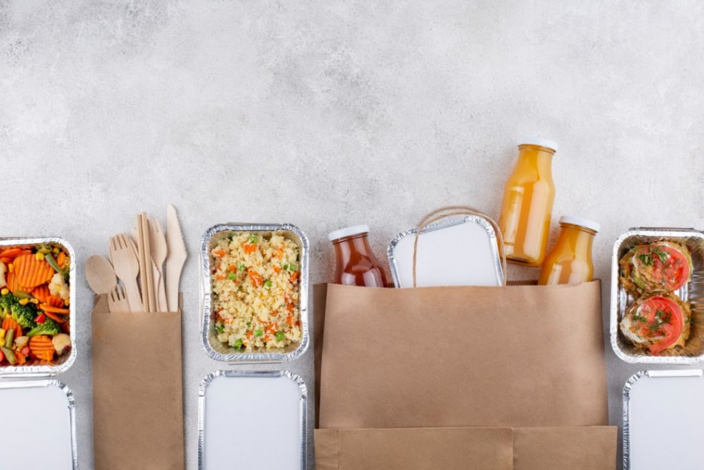 Eco-friendly food packaging displayed on a table, highlighting sustainable packaging benefits for the F&B industry.